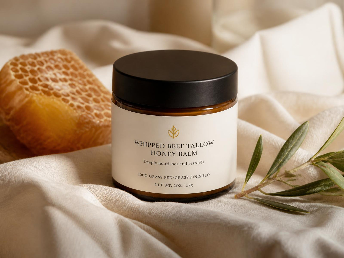 Tallow Theory whipped beef tallow and raw honey balm jar on cream linen with honeycomb